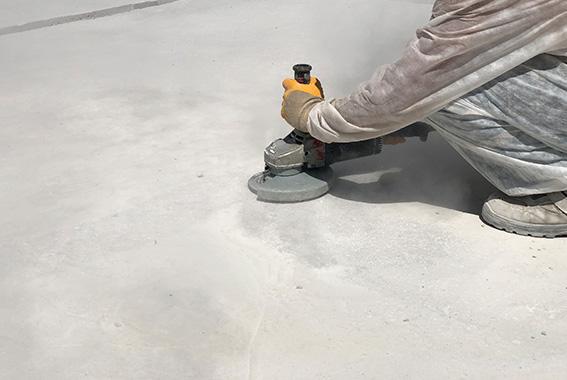 Close up of worker's hands using angle grinder